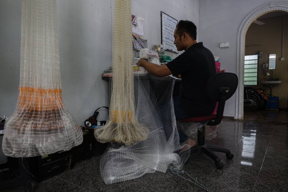 With his sewing machine invention, Amzar explained that a fishing net can now be completed in a day. Photo by Bernama