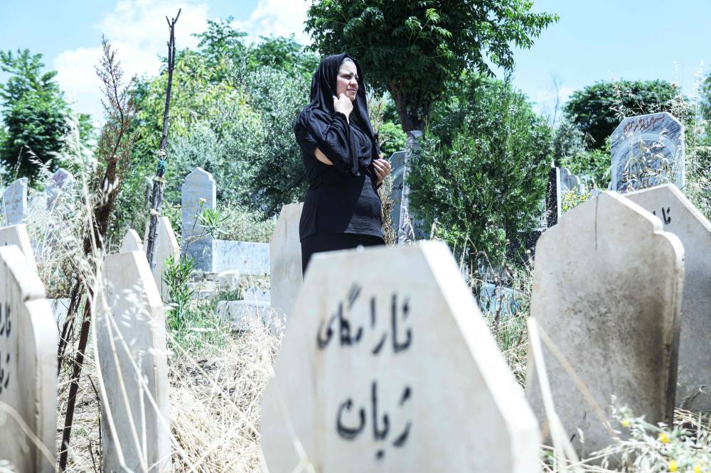 Lawyer and activist Rozkar Ibrahim, walks past a headstone marked with the word 'Grave of life' in an area reserved for the victims of femicide and honour killings, at the Siwan cemetery in Sulaimaniyah. Photo by Shwan Mohammed/ AFP