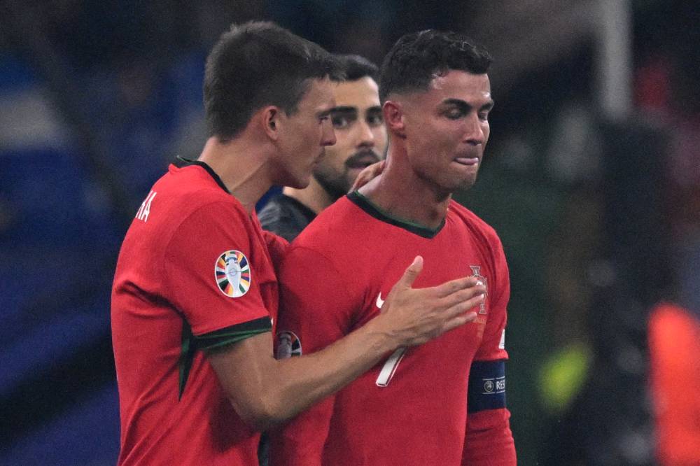 Portugal's forward #07 Cristiano Ronaldo (R) reacts to a missed penalty kick during the UEFA Euro 2024 round of 16 football match between Portugal and Slovenia at the Frankfurt Arena in Frankfurt am Main on July 1, 2024. (Photo by AFP)