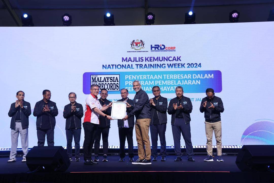 HRD Corp CEO Datuk Shahul Dawood received a certificate of recognition for the Largest Participation in a Lifelong Learning Programme from Malaysia Book of Records (MBR) CEO Christopher Wong, witnessed by Prime Minister Datuk Seri Anwar Ibrahim and Human Resources Minister Steven Sim.