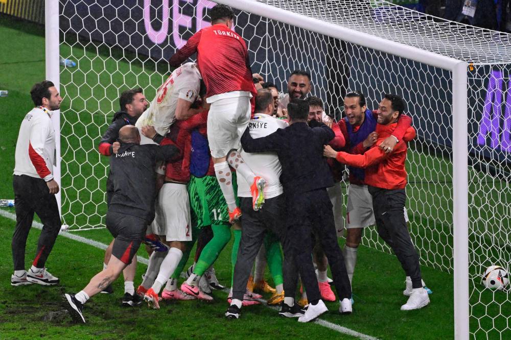 Turkey's players and team members celebrate after winning the UEFA Euro 2024 round of 16 football match between Austria and Turkey at the Leipzig Stadium in Leipzig on July 2, 2024. (Photo by AFP)