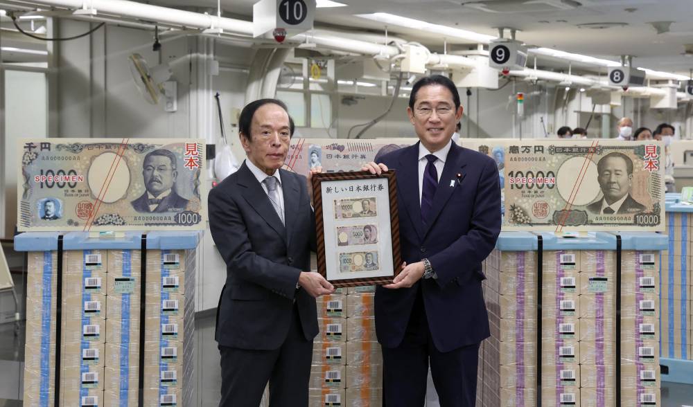 Japan's Prime Minister Fumio Kishida (R) poses for a commemorative photo with Bank of Japan Governor Kazuo Ueda at the Bank of Japan headquarters in Tokyo on July 3, 2024, to mark the issuance of new yen banknotes. - (Photo by JIJI PRESS / AFP)