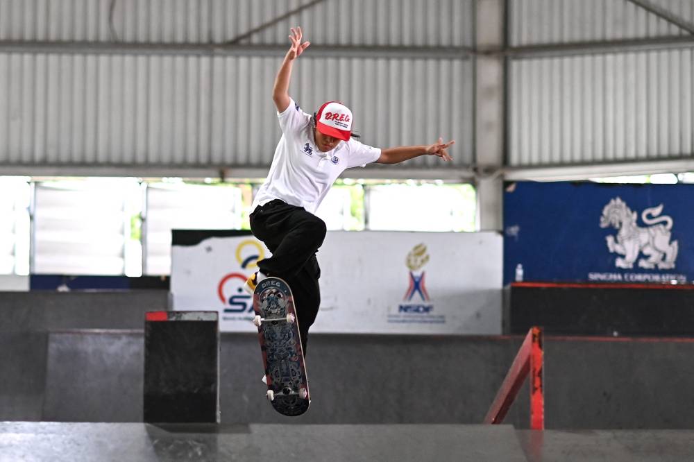 This photo taken on June 27, 2024 shows 12-year-old Thai skateboarder Vareeraya Sukasem taking part in a training session at Hua Mak skate park in Bangkok. - (Photo by MANAN VATSYAYANA / AFP)