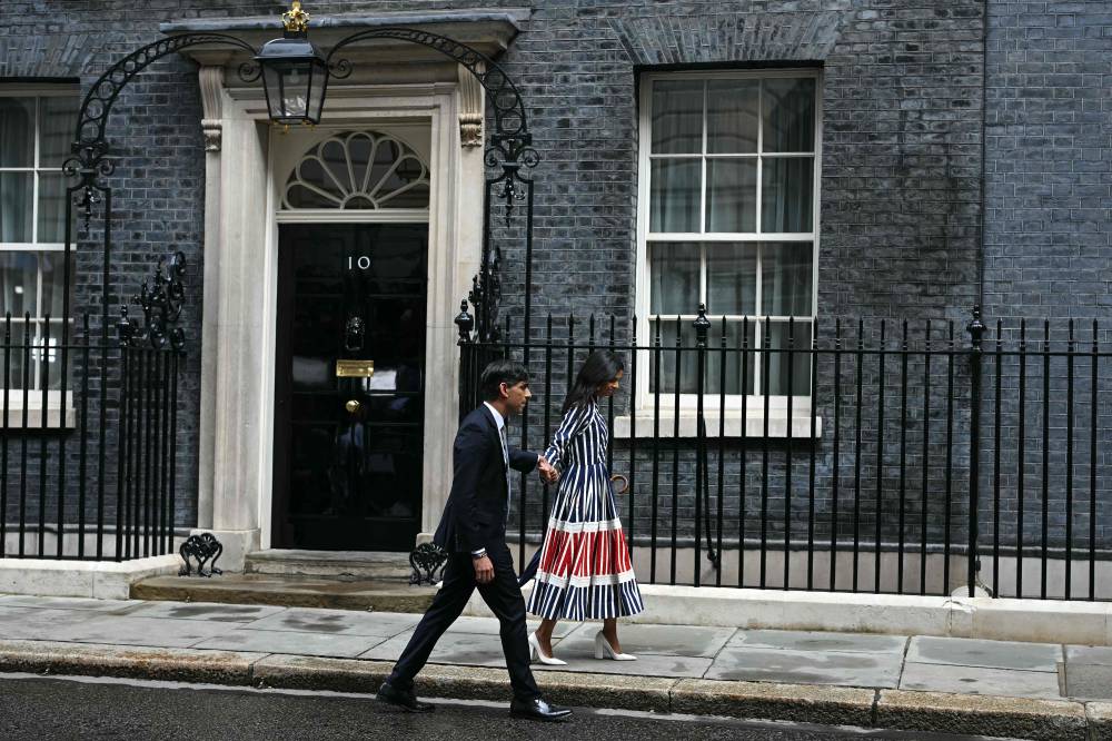 Britain's outgoing Prime Minister and leader of the Conservative party, Risihi Sunak, and his wife Akshata Murty, walk to a car as they leave after he delivered a statement after losing the general election, outside 10 Downing Street in London on July 5, 2024. - Photo by AFP