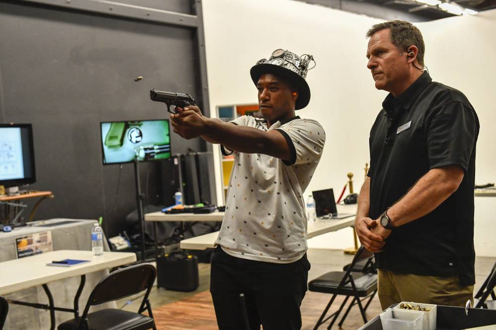 Film and TV armourer and prop master Dutch Merrick (R) demonstrates how to use a gun safely while having a student fire blank ammunition during his Prop Gun safety workshop on how to handle guns safely on set, in Glendale, California, on July 3, 2024. - (Photo by VALERIE MACON / AFP)