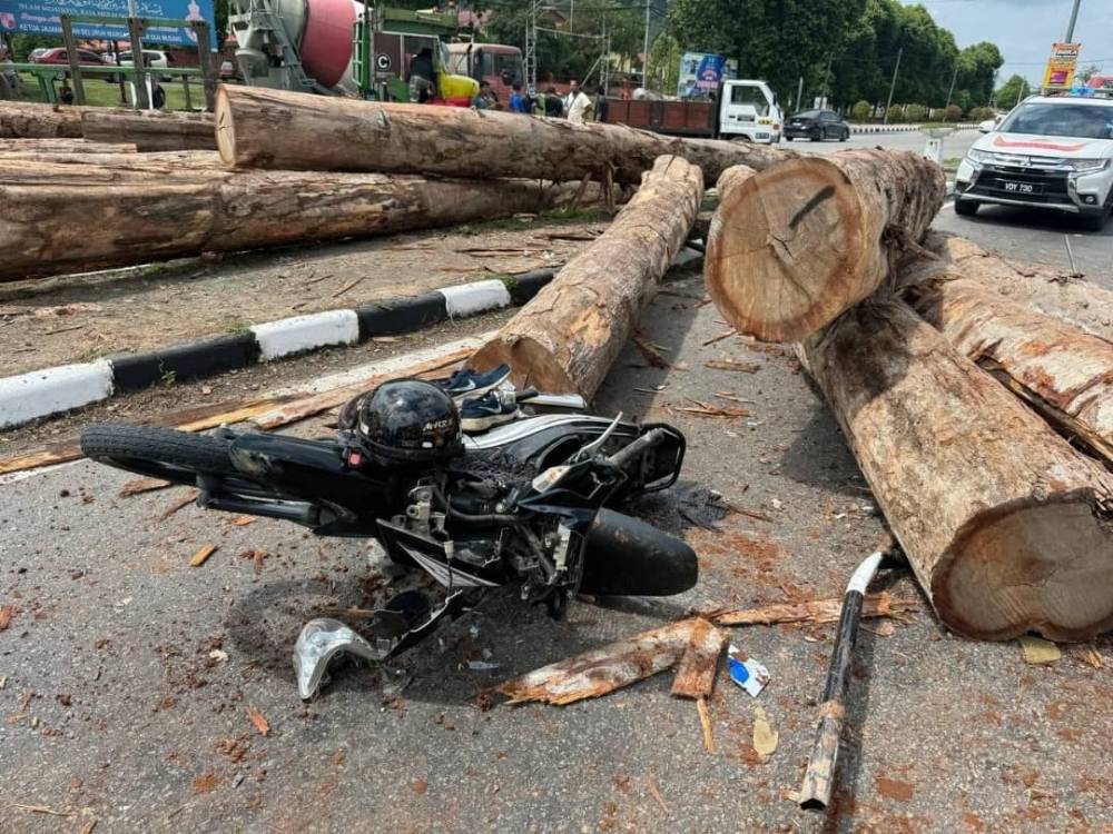 Yesterday, a woman narrowly cheated death when the motorcycle she was riding was crushed by several logs that came tumbling from a lorry while she stopped at the traffic lights. 