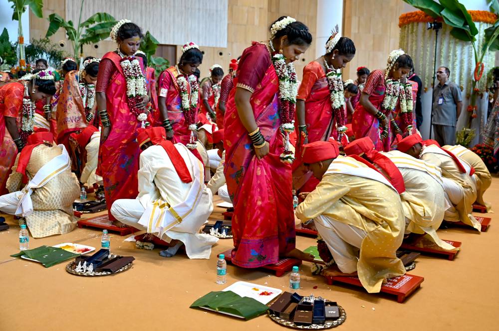 Underprivileged couples take part in a mass wedding ceremony ahead of the wedding of billionaire tycoon and Chairman of Reliance Industries Mukesh Ambani's son Anant Ambani to Radhika Merchant, at Reliance Corporate Park in Navi Mumbai on July 2, 2024. - (Photo by PUNIT PARANJPE / AFP)
