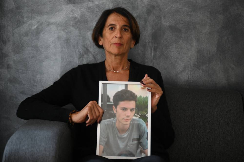 Marie-Noelle Cullieret-Combalat poses with a portrait of her son Bastien, who committed suicide at the age of 24, in Marseille, southern France, on Feb 13, 2024. - (Photo by NICOLAS TUCAT / AFP)