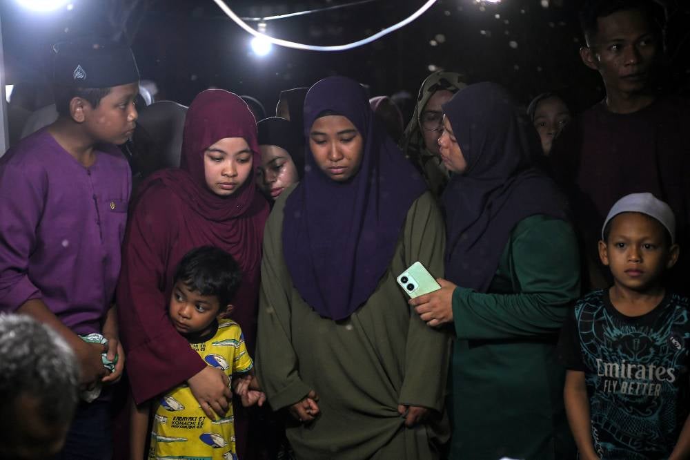 Nurain Hasnorizal (third from left) during the burial of Muhammad Akil Syauqi. Bernama FILE PIX