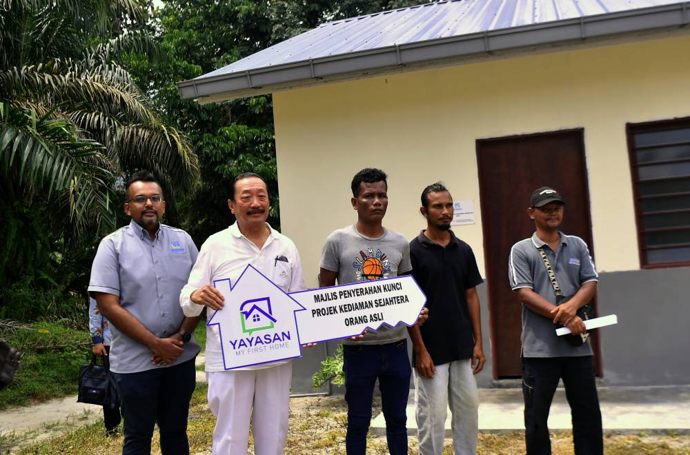 My First Home Foundation founder and advisor Tan Sri Vincent Tan (second from left) presents a replica key to recipient, Bahjuga A/L Bahchem, 39 (third from right), at the Handing Over Ceremony of Sejahtera Indigenous Residences in Kampung Bindu, Chenderiang.
