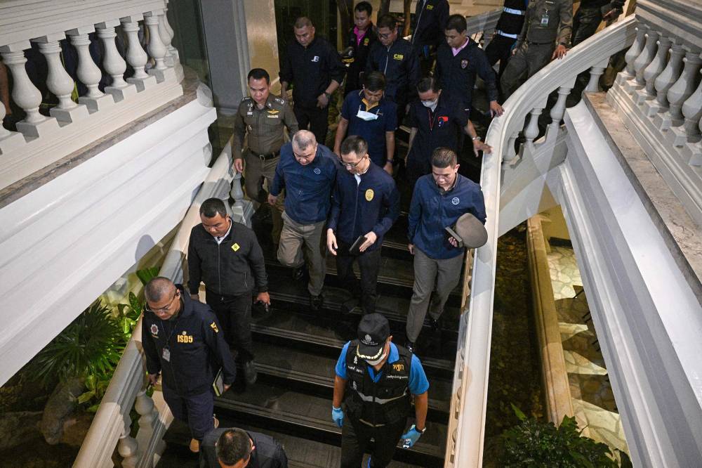 Policemen inspect after an incident, in which six bodies were found at a hotel in Bangkok on July 16, 2024. Six people believed to be Vietnamese and Vietnamese-Americans were found dead in a hotel room in central Bangkok on July 16, a senior police officer said. (Photo by AFP)