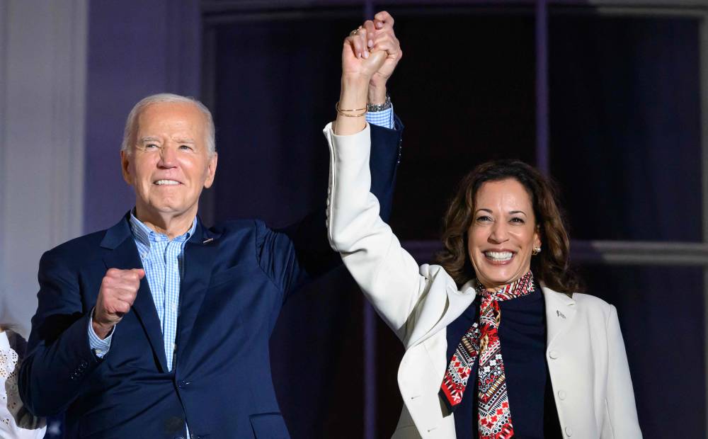 (FILES) US President Joe Biden (L) and US Vice President Kamala Harris hold hands and gesture as they watch the Independence Day fireworks display from the Truman Balcony of the White House in Washington, DC, on July 4, 2024. (Photo by Mandel NGAN / AFP)