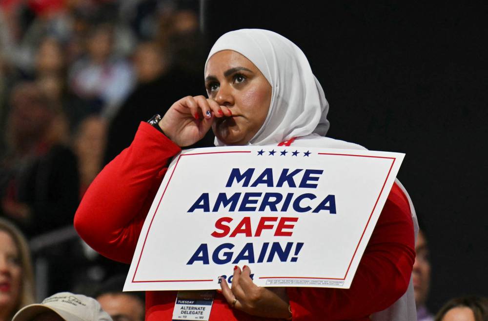 An attendee holds a "Make America Safe Again" during the second day of the 2024 Republican National Convention at the Fiserv Forum in Milwaukee, Wisconsin, July 16, 2024. (Photo by ANGELA WEISS / AFP)