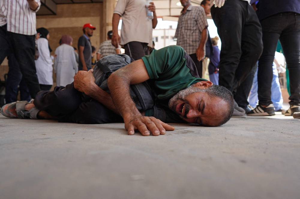 A Palestinian man reacts as casualties are rushed to Nasser hospital in Khan Yunis following Israeli bombardment east of the city in the southern Gaza Strip on July 22, 2024. (Photo by AFP)