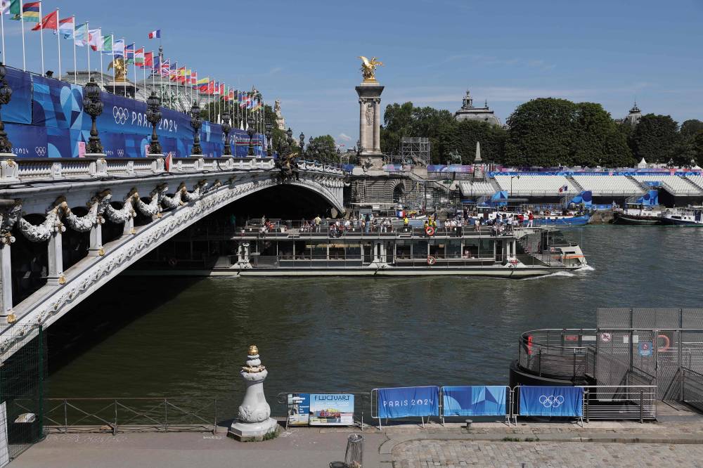 A tourist boat navigates on the Seine river under the Alexandre III bridge, after the first triathlon training session was cancelled during the Paris 2024 Olympic Games in Paris, on July 28, 2024, due to the pollution of the Seine river. - Photo by AFP