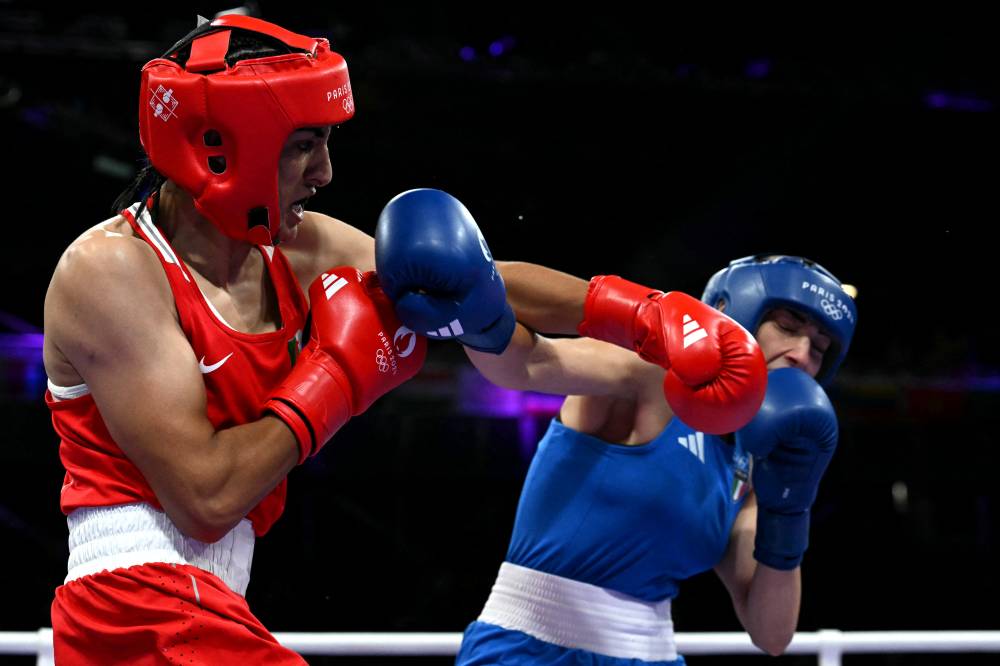 Algeria's Imane Khelif (in red) punches Italy's Angela Carini in the women's 66kg preliminaries round of 16 boxing match during the Paris 2024 Olympic Games at the North Paris Arena, in Villepinte on Aug 1, 2024. - (Photo by MOHD RASFAN / AFP)