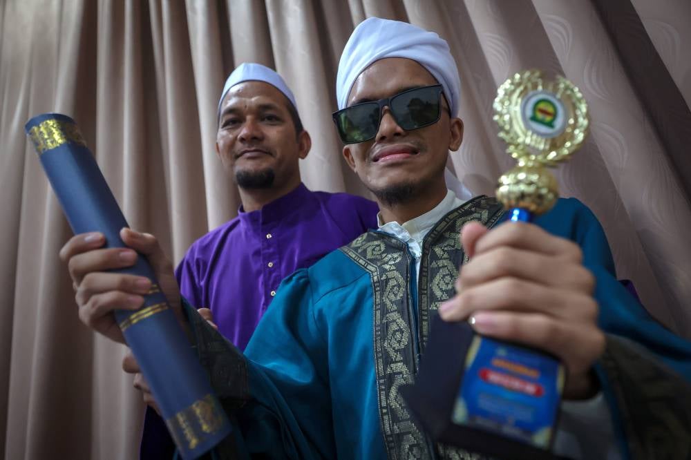 Despite being visually-impaired, Amzar Haziq Md Fauzi demonstrates that his faith and determination are far from blind. Photo by Bernama