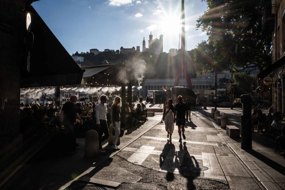 This photo taken in Lyon, on July 22, 2024 shows a cafe terrace where misters have been installed to cool off cutsomers during a heatwave. (Photo by AFP)