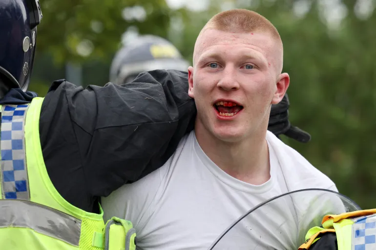 A man is detained by a police officer during an anti-immigration riot in Rotherham, England. (Photo by Hollie Adams/Reuters)