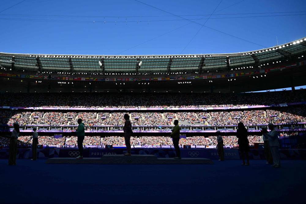 Silver medallist Hungary's Bence Halasz (center L), gold medallist Canada's Ethan Katzberg (C) and bronze medallist Ukraine's Mykhaylo Kokhan (center R) stand on the podium during the victory ceremony for the men's hammer throw athletics event during the Paris 2024 Olympic Games at Stade de France in Saint-Denis, north of Paris, on August 5, 2024. (Photo by AFP)