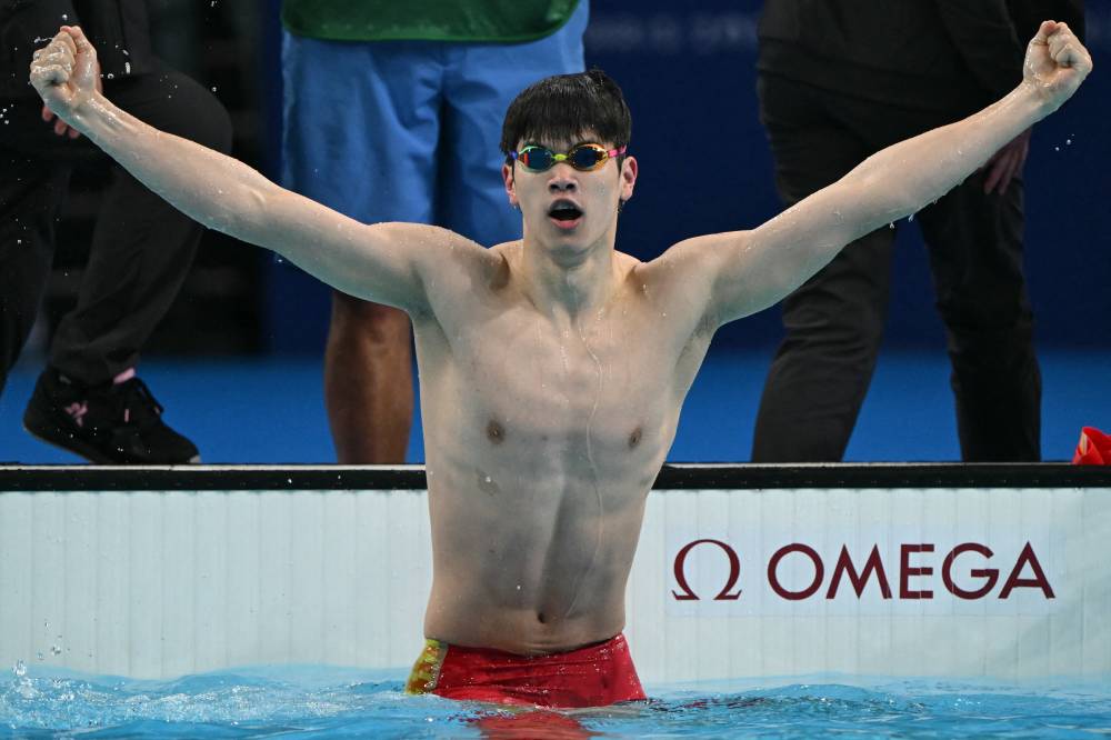 China's Pan Zhanle reacts after winning gold and breaking a world record in the final of the men's 100m freestyle swimming event during the Paris 2024 Olympic Games at the Paris La Defense Arena in Nanterre, west of Paris, on July 31, 2024. (Photo by AFP)