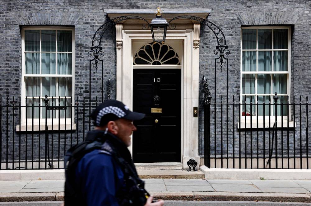 A police officer passes the door to 10 Downing Street, the official residence of Britain's Prime Minister, in central London on August 5, 2024. - Photo by AFP