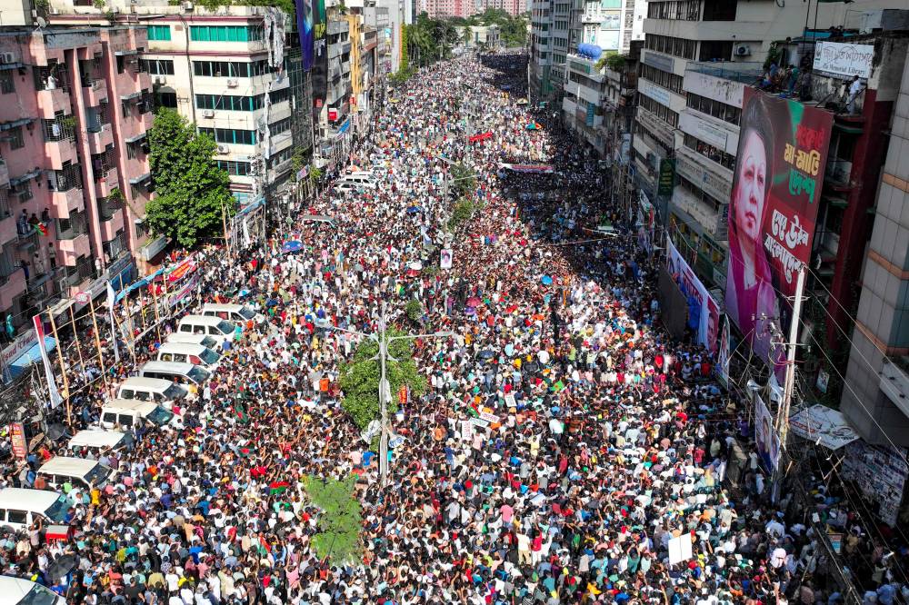 In this aerial photograph Bangladesh Nationalist Party (BNP) activists gather near a poster of BNP chairperson Khaleda Zia, during a rally in Dhaka on August 7, 2024. - Photo by AFP