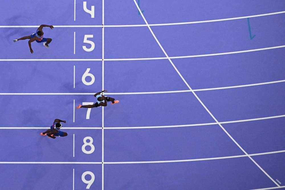 Botswana's Letsile Tebogo (R) crosses the finish line ahead of US' Kenneth Bednarek (down) and US' Noah Lyles (up) to win the men's 200m final of the athletics event at the Paris 2024 Olympic Games at Stade de France in Saint-Denis, north of Paris, on August 8, 2024. (Photo by AFP)