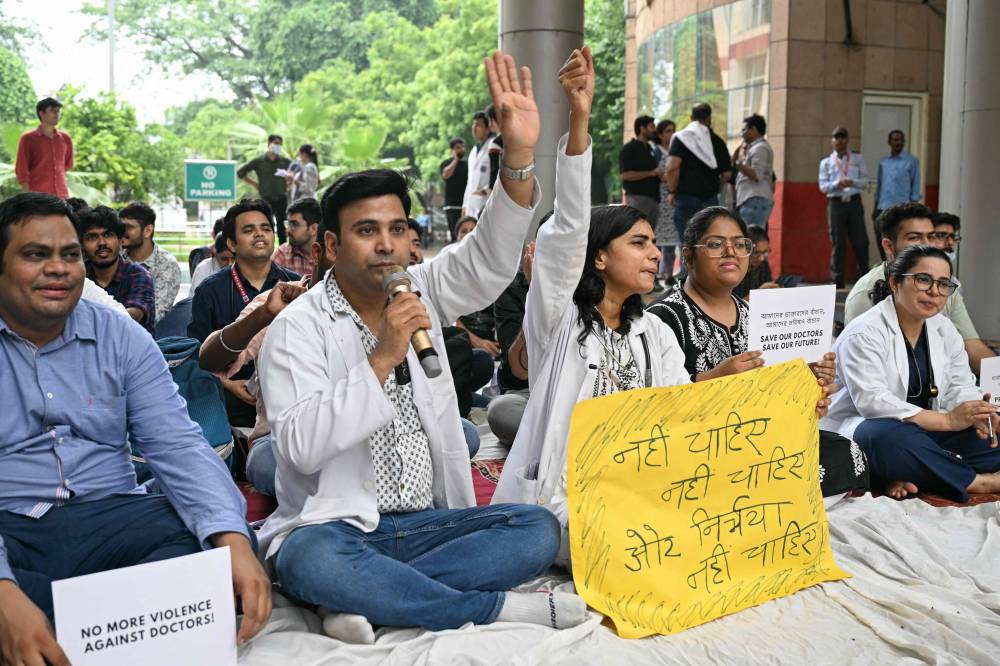 Practicing doctors and medical staff display placards as they take part in a protest against the incident of rape and murder of a young medic in Kolkata, during a demonstration held at a government hospital in New Delhi on August 12, 2024. - Photo by AFP