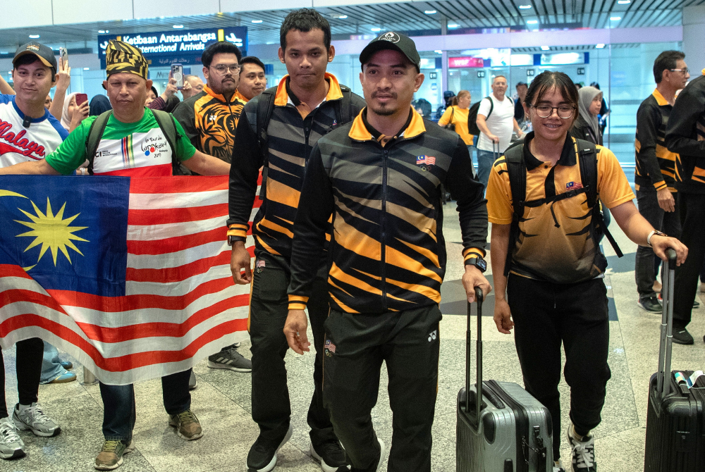 Azizulhasni (second, right) with Muhammad Shah Firdaus Sahrom (third, right) and Nurul Izzah Izzati Mohd Asri (right) at the KLIA yesterday. - Photo by Bernama