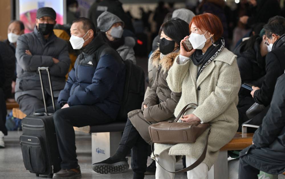 People wearing face masks sit on benches at Seoul railway station in Seoul on Jan 30, 2023, after South Korea lifted its indoor mask mandate as Covid cases dwindle. - (Photo by Jung Yeon-je / AFP)