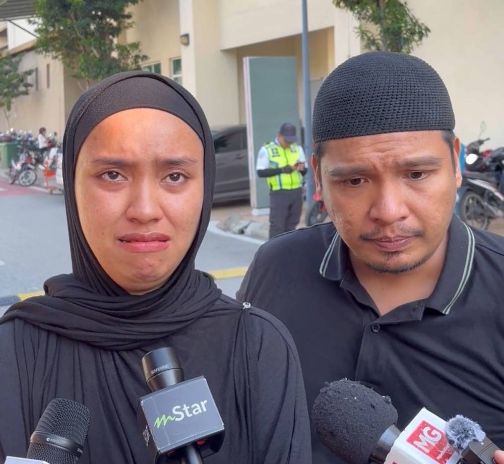 Irfahanie (left) and her husband when met in front of the Forensic Medical Unit at Shah Alam Hospital on Thursday.