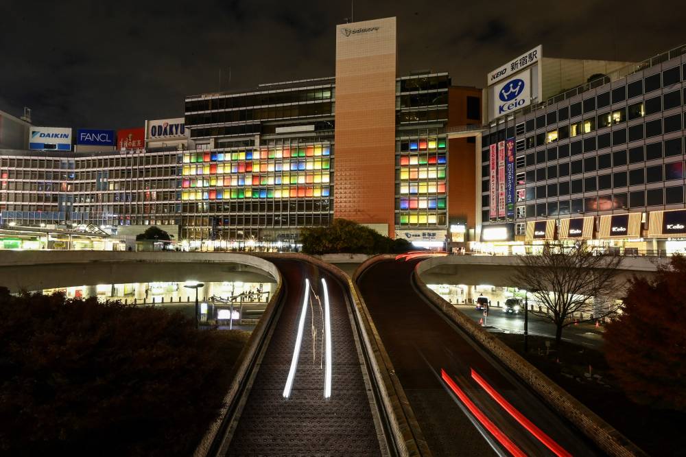 This general view shows a night view over Shinjuku train station, one of the busiest stations in the world, in Tokyo on Dec 21, 2022. - (Photo by Richard A. Brooks / AFP)