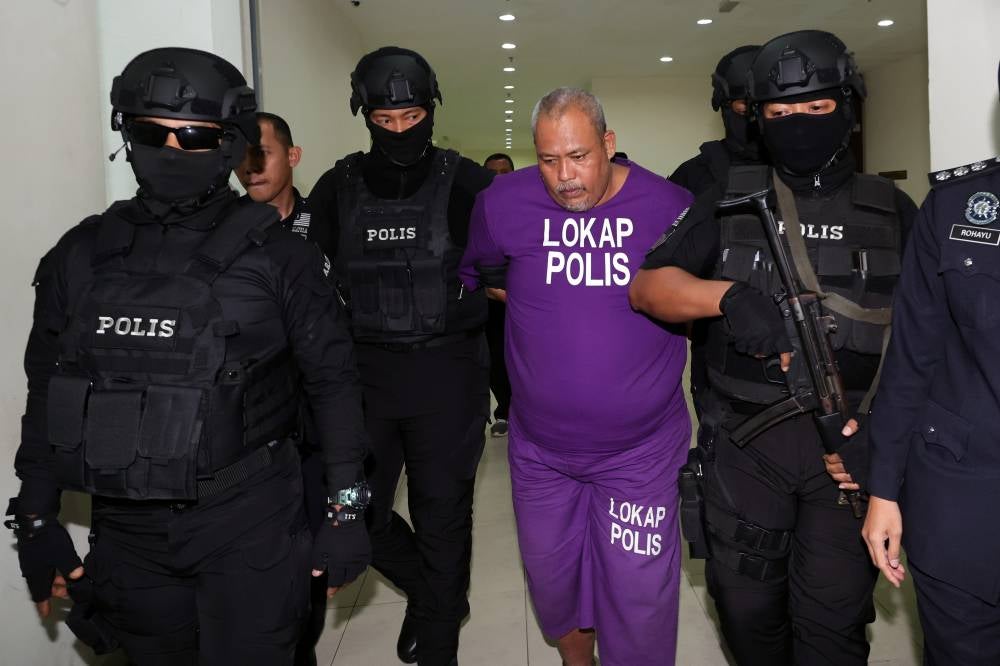 Azman Mohamed Nor, 48, was charged in the Magistrate's Court today with the murder of his elderly parents and a niece in a house in Kampung Paya Redan, Pagoh, on Aug 9. - Photo by Bernama