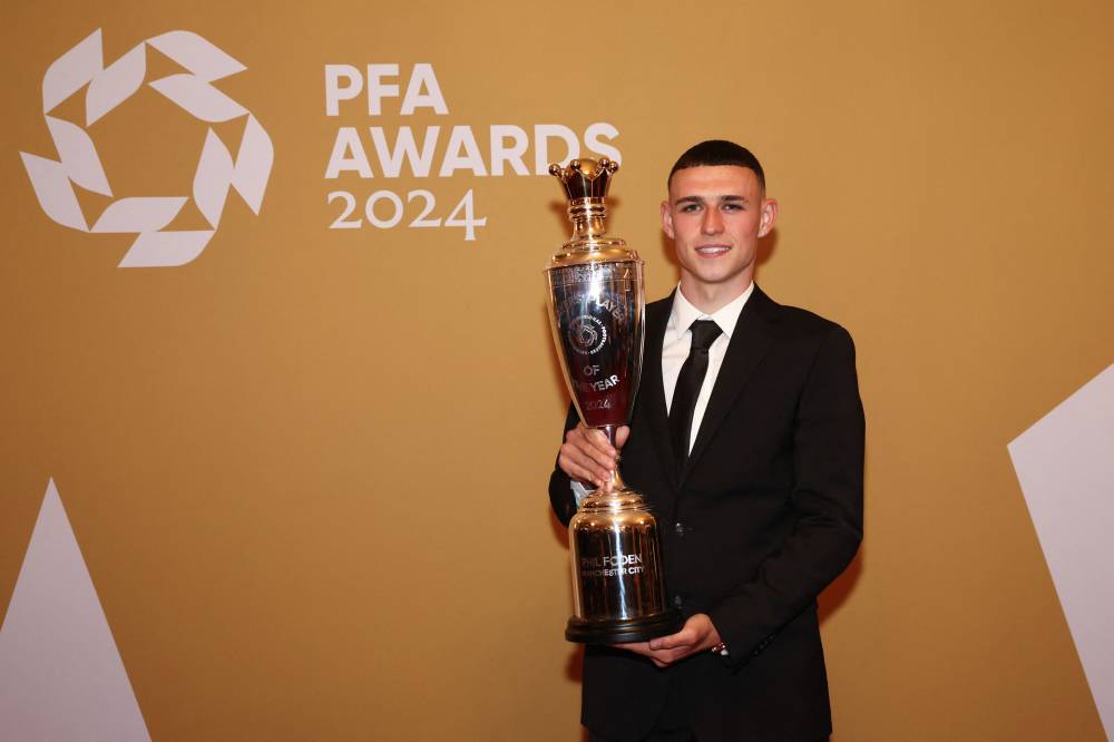 Manchester City's English midfielder Phil Foden poses Men's PFA Players' Player of the Year award in the winners backstage during the 2023-2024 Professional Footballers' Association (PFA) awards, at the Opera House, in Manchester, northern England, on August 20, 2024. (Photo by AFP)