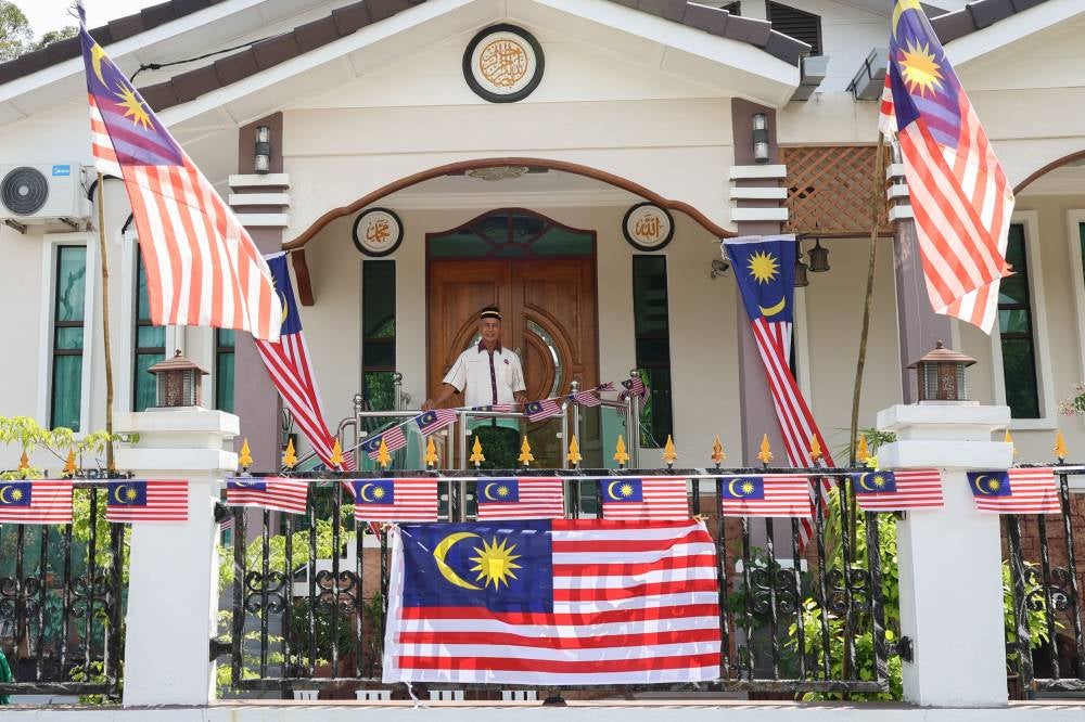 Retired soldier Abu Bakar Jusoh, 69, spends RM500 each year to decorate his home with the Jalur Gemilang for National Day. - Photo by Bernama