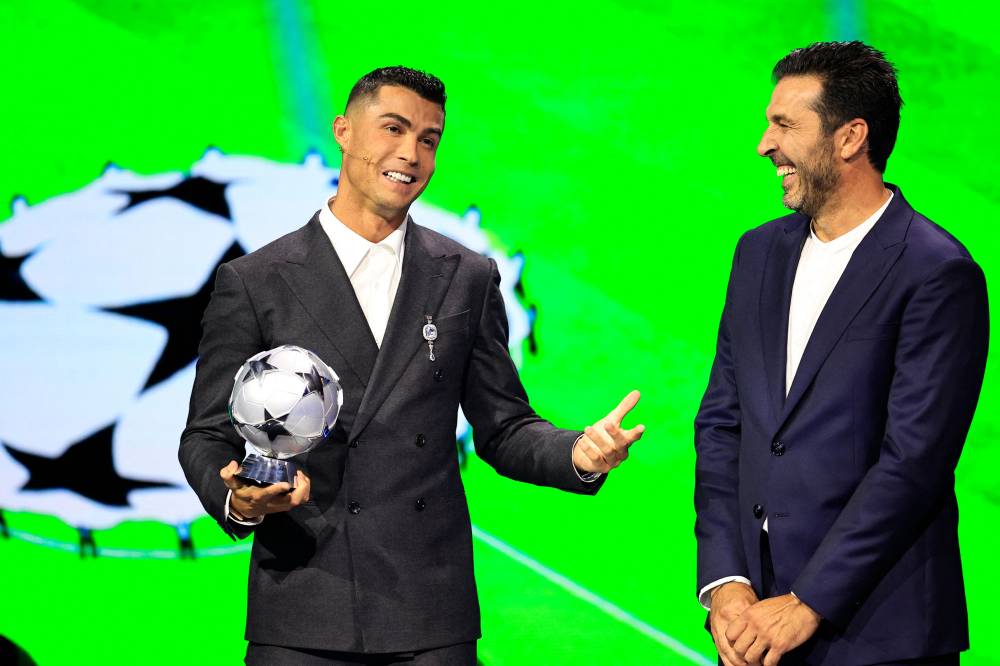 Portugal's national team player and Saudi Al-Nassr's forward Cristiano Ronaldo who is awarded the All-Time Goalscorer Award in the UEFA Champions League (L) and Italy's former goalkeeper Gianluigi Buffon who awarded the 2024 UEFA President's Award pose ojn stage during the ceremony of the draw for the group stage of the 2024-2025 UEFA Champions League football tournament, at the Grimaldi Forum in Monaco on August 29, 2024. (Photo by AFP)