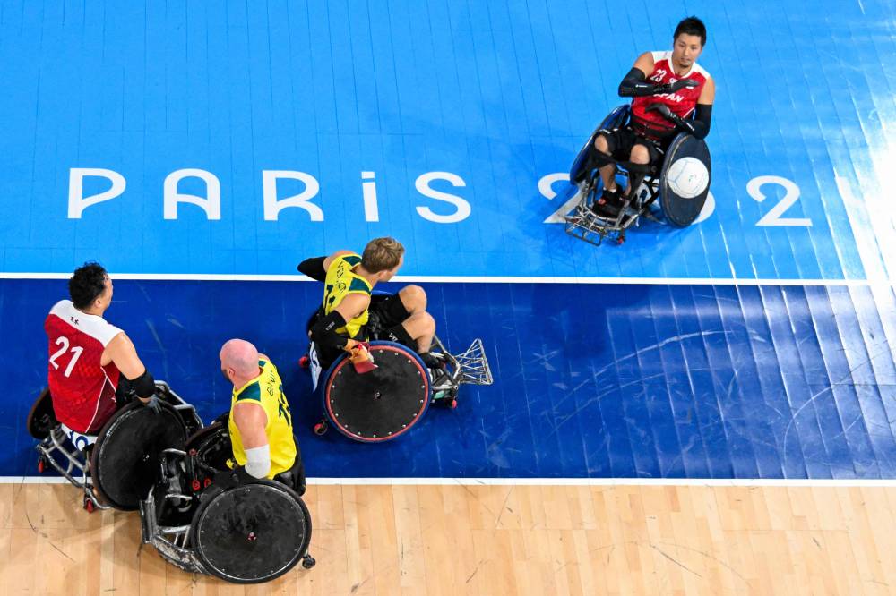 This overview shows Japan's Hitoshi Ogawa (R) in action against the Australian team during the semi-final wheelchair rugby match, during the Paris 2024 Paralympic Games at the Champ-de-Mars Arena in Paris on September 01, 2024. (Photo by Fran?ois-Xavier MARIT / AFP)