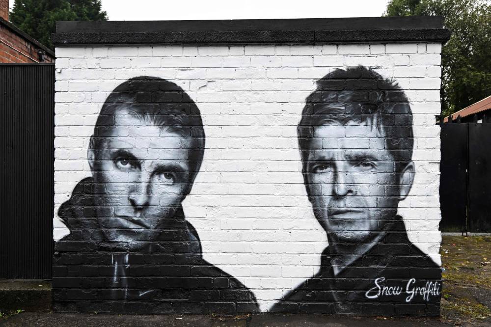A photograph taken on September 2, 2024 shows a mural created by artist Scott Wilcock aka Snow Graffiti, depicting Liam Gallagher (L) and Noel Gallagher (R) members of the British rock band Oasis, and painted outside the pub Whitefield, near Heaton Park, in Manchester, northern England. Oasis, which was integral to the 1990s Britpop scene but split in 2009, announced on August 27, 2024 it will reunite next year for a worldwide tour, starting with 17 concerts in the UK and Ireland. - Photo by AFP