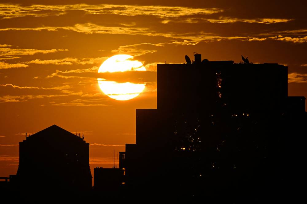 The sun rises against high-rise buildings in Beijing on September 6, 2024. China logged its hottest August in more than six decades last month, its national weather service said, after the country endured a summer of extreme weather and heatwaves across much of its north and west. (Photo by AFP)