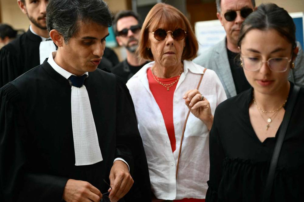 Gisele P. (centre) escorted by her lawyer Stephane Babonneau (left) and one of her sons leaves the courthouse during the trial of her husband accused of drugging her for nearly ten years and inviting strangers to rape her at their home in Mazan, a small town in the south of France in Avignon. Photo by Christophe Simon/AFP
