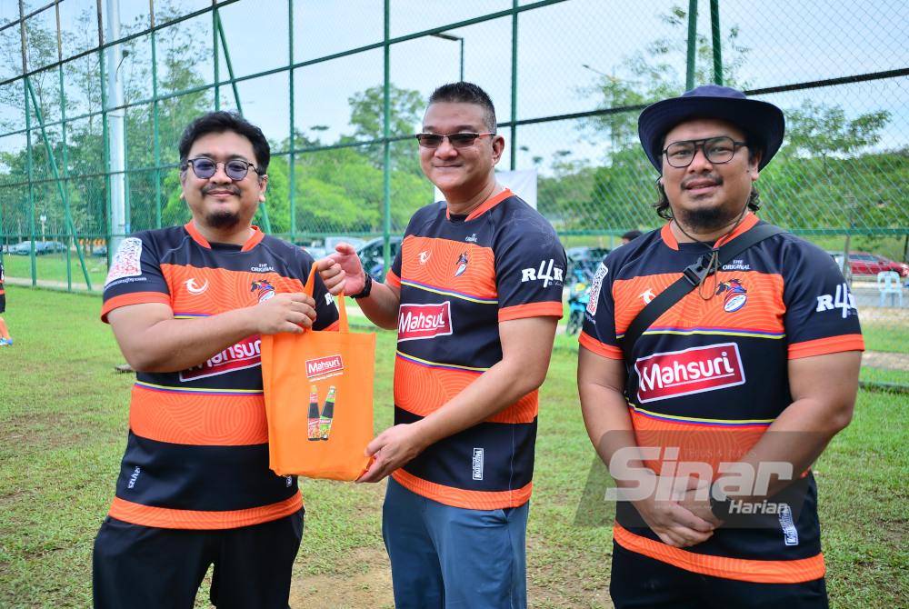 Jazri (center) presented a souvenir to Eznan Fahim during a friendly match organised by Elmina Bronco on Sunday. Photo by Asril Aswandi Shukor/SINAR