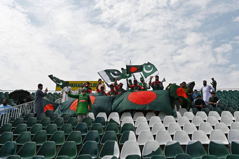 Bangladesh and Pakistan fans wave their national flags as they watch the fifth and final day of the second and last Test cricket match between Pakistan and Bangladesh, at the Rawalpindi Cricket Stadium in Rawalpindi on September 3, 2024. (Photo by AFP)
