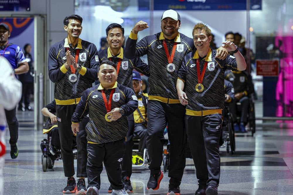 2024 Paralympic Games medalists (from left) Datuk Abdul Latif Romly, Bonnie Bunyau Gustin, Eddy Bernard, Muhammad Ziyad Zolkefli and Cheah Liek Hou upon their arrival at KLIA, last night. 