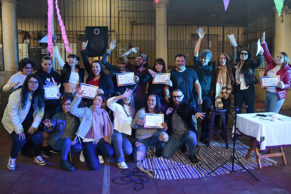 Inmates pose for a picture with some of the facilitators during the closing of a stand-up comedy workshop at the El Buen Pastor women's prison in Asuncion. - Photo by AFP