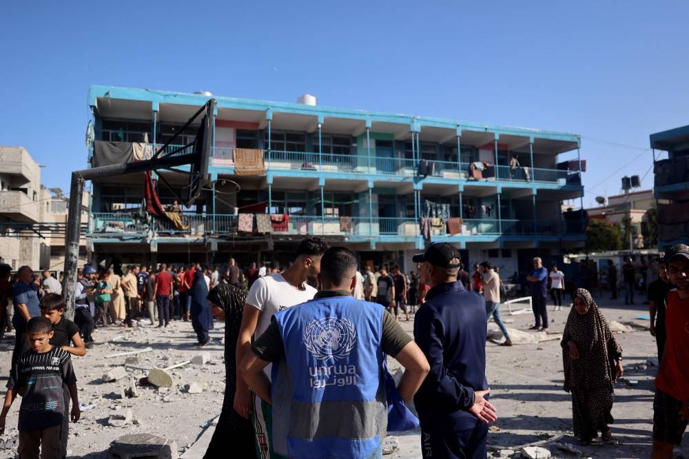 A member of the United Nations Relief and Works Agency for Palestine Refugees (UNRWA) checks the courtyard of a school after an Israeli air strike hit the site, in Nuseirat in the central Gaza Strip on September 11, 2024, amid the ongoing destruction by Israel. (Photo by Eyad BABA / AFP)