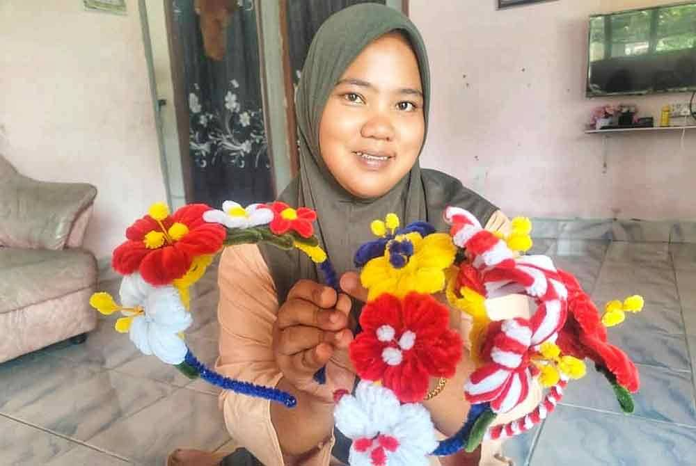 Siti Nur Natrah showcases the hibiscus-themed hairbands she created and sells online.
