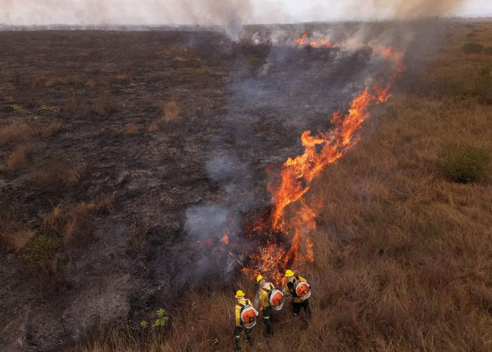 Aerial view of firefighters working on a fire outbreak in a rural area of Corumba, Mato Grosso do Sul State, Brazil on June 26, 2024. - Photo by AFP