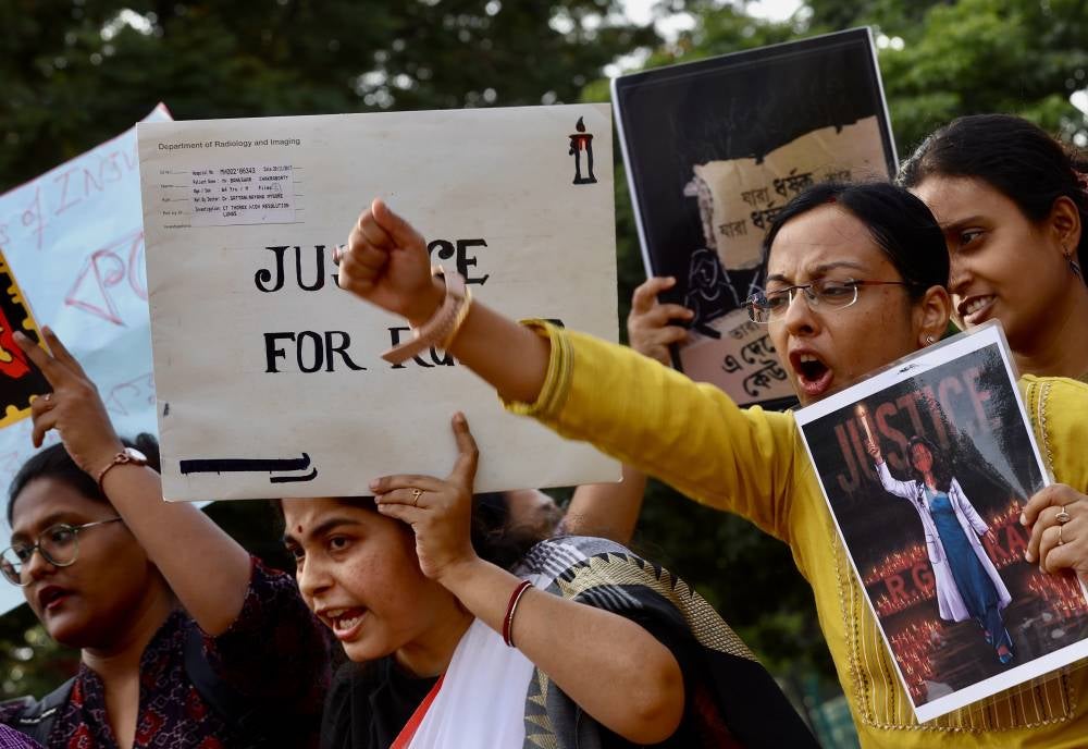 Protesters hold placards and shout slogans during a protest to call for justice following an alleged rape and murder of a trainee doctor. EPA FILE PIX