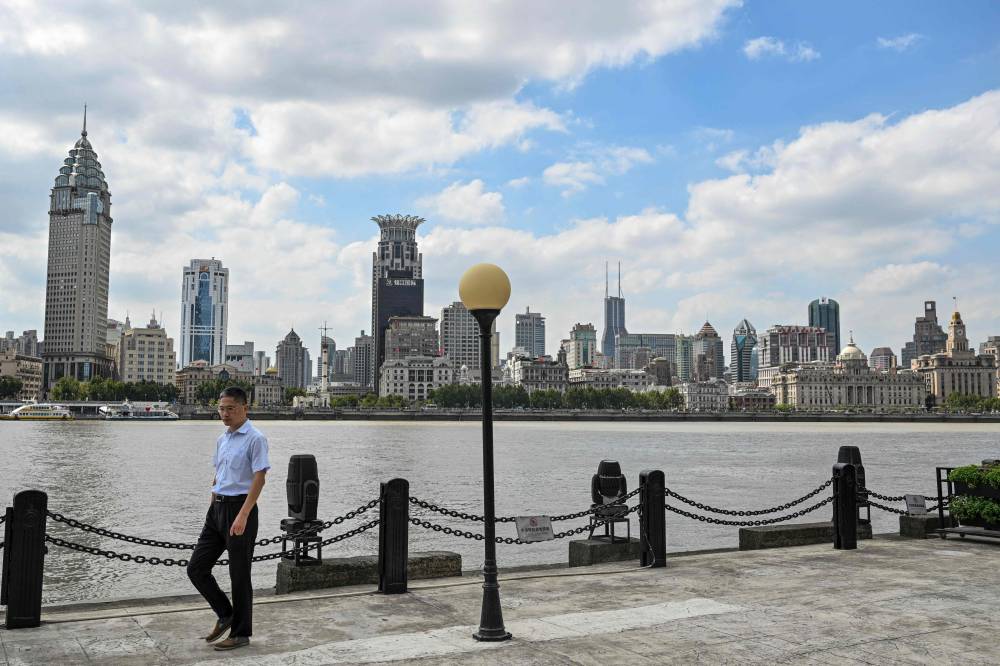 A man walks along the bank of the Huangpu River at the financial district of Lujiazui in Shanghai on September 23, 2024. (Photo by AFP)
